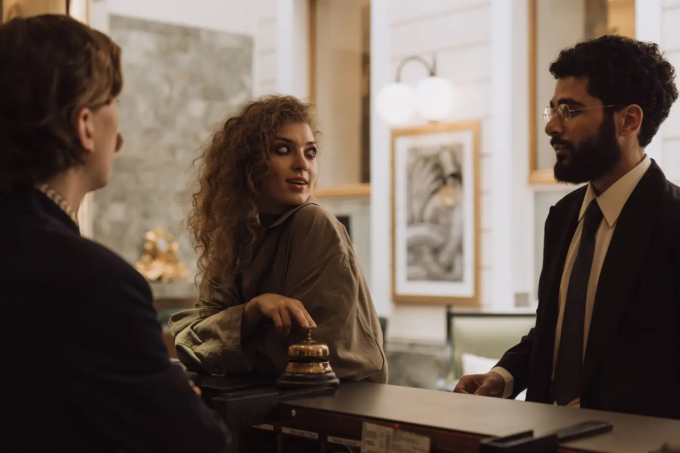 Gasten en medewerkers bij de balie van een hotel