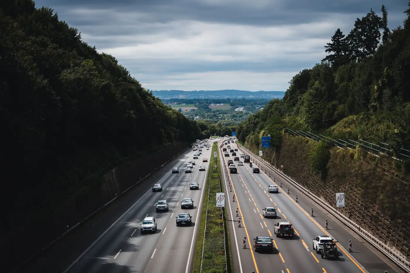 Snelweg door een bos in Duitsland onder een bewolkte lucht