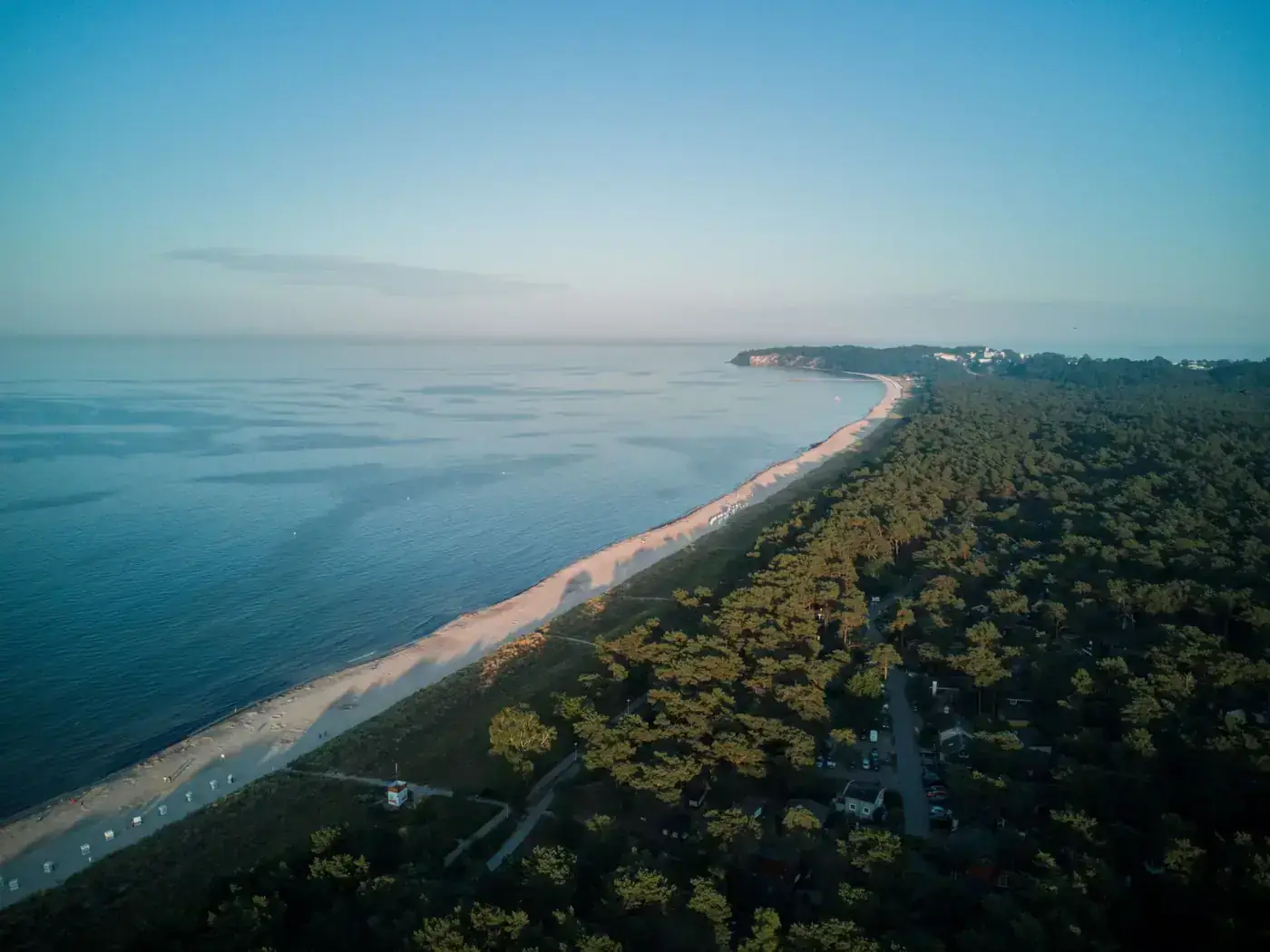 A stunning aerial view of Usedom Island's coastline with a forest and beach at sunrise, capturing nature's tranquility.