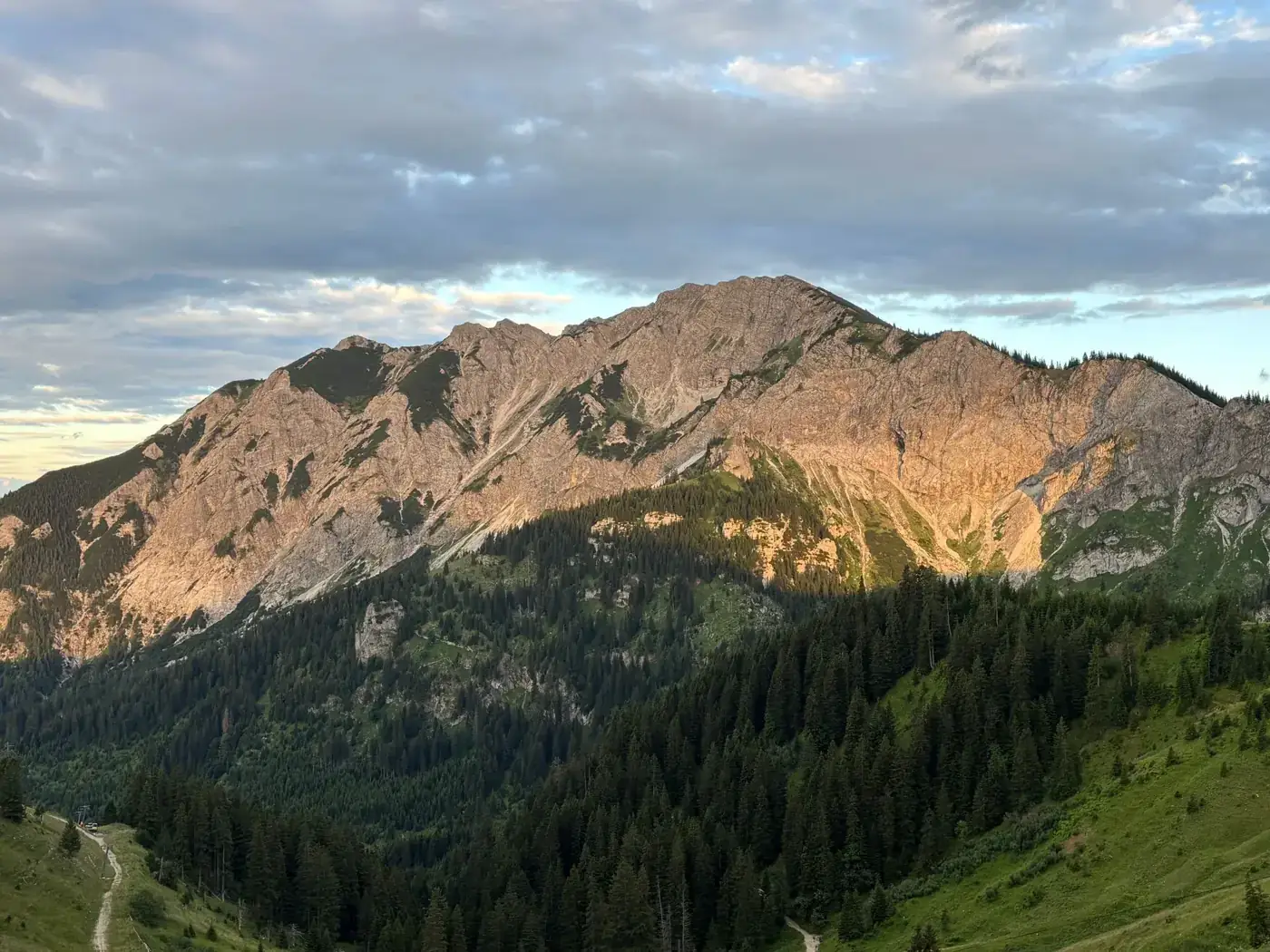 Majestic Bavarian Alps at sunset with lush greenery and a serene sky.
