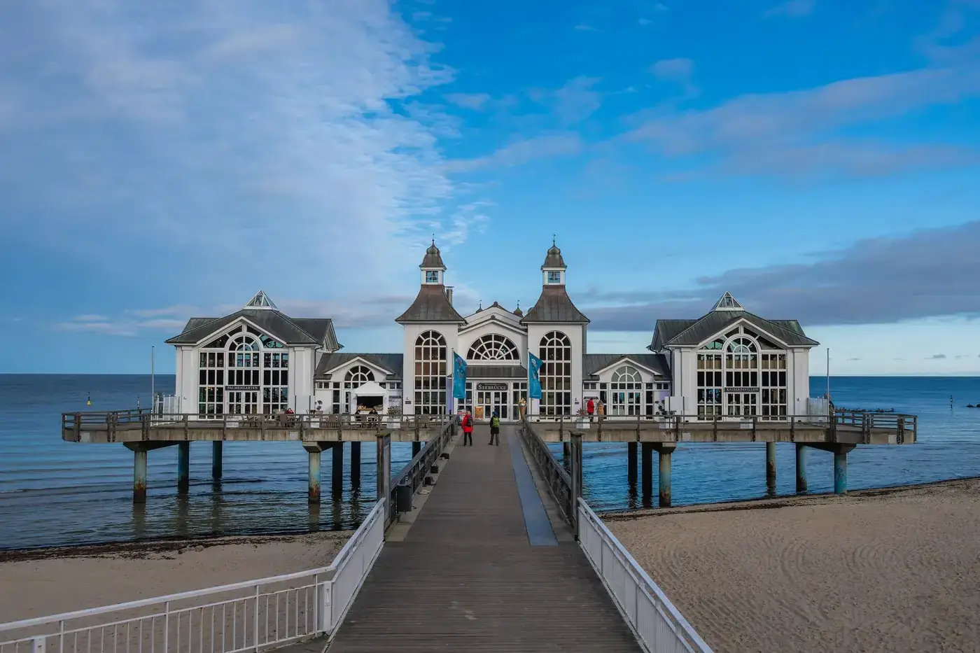 A scenic view of the pier and pavilion on Rügen Island with a clear blue sky backdrop.
