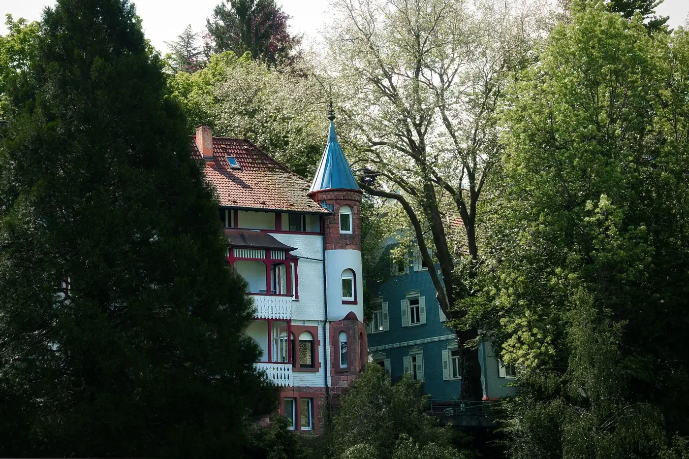 A picturesque Bavarian-style house nestled among lush trees in Bad Herrenalb, Germany.