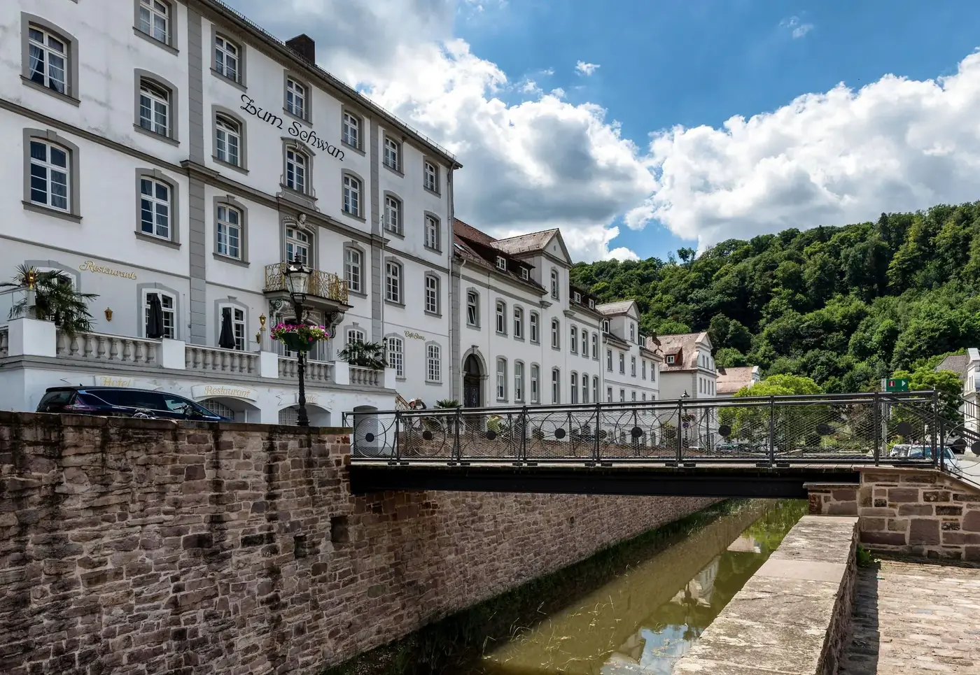 Picturesque view of historic buildings in Bad Karlshafen, Hessen, Germany, featuring a quaint bridge and lush greenery.