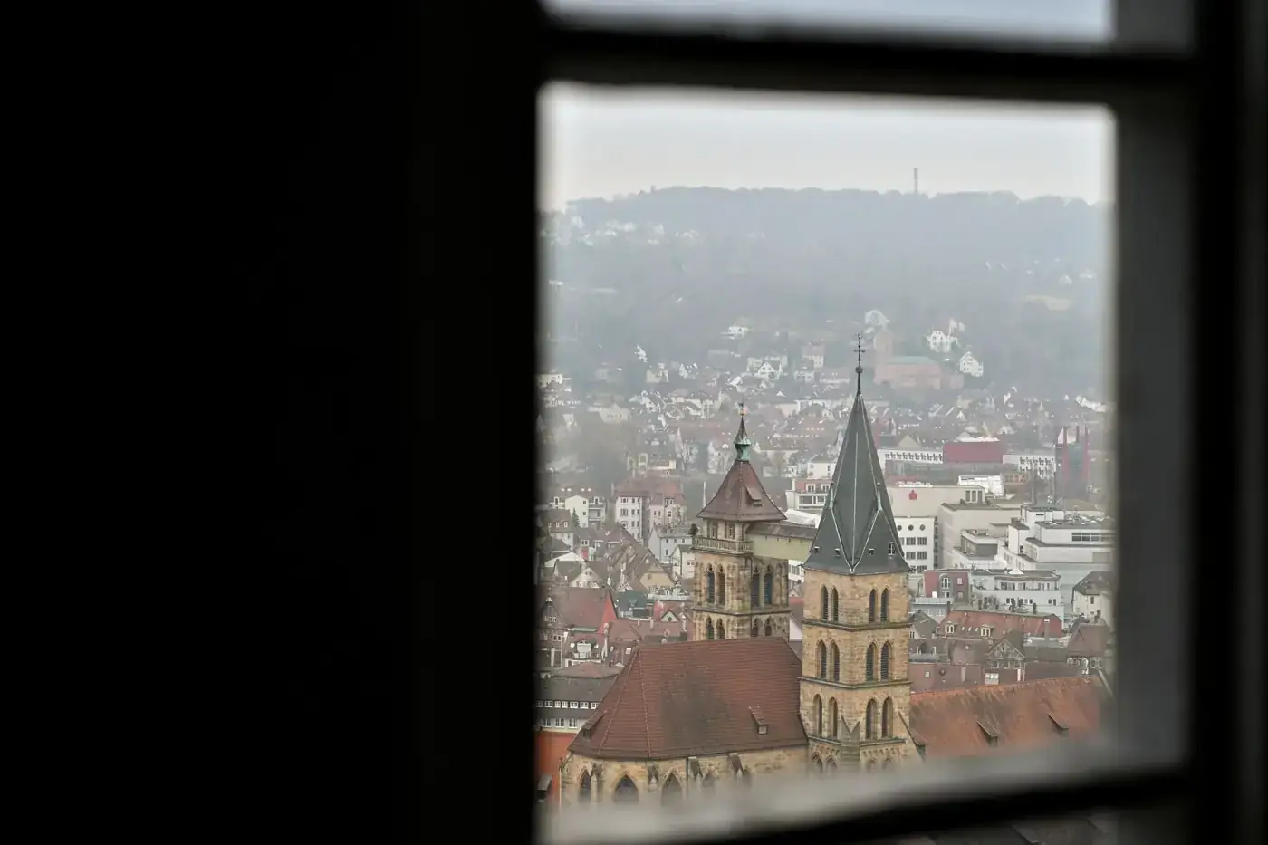 Cityscape of Stuttgart viewed through a window with a focus on historical architecture.