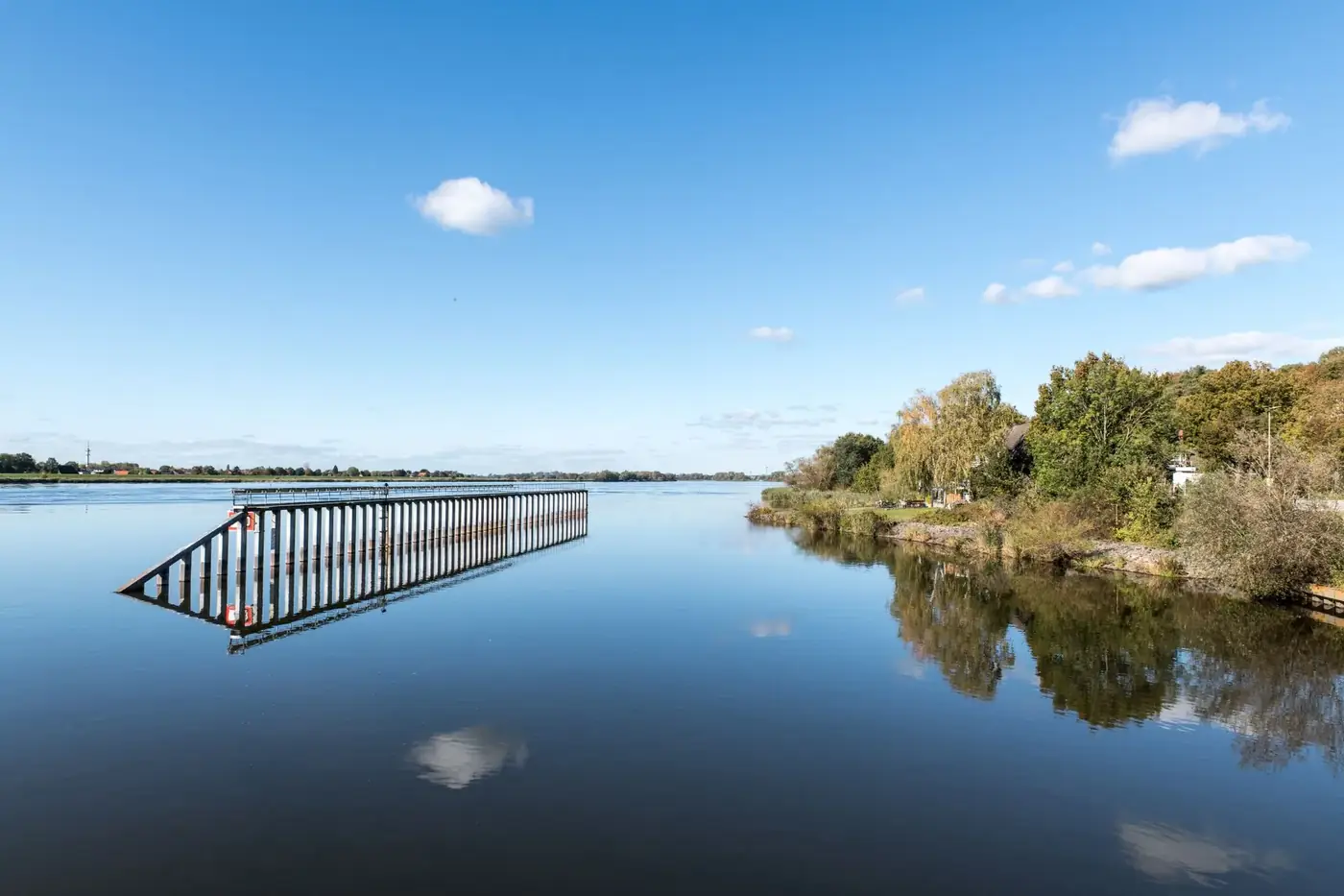 Tranquil morning view of the Elbe River with reflections in Geesthacht, Germany.