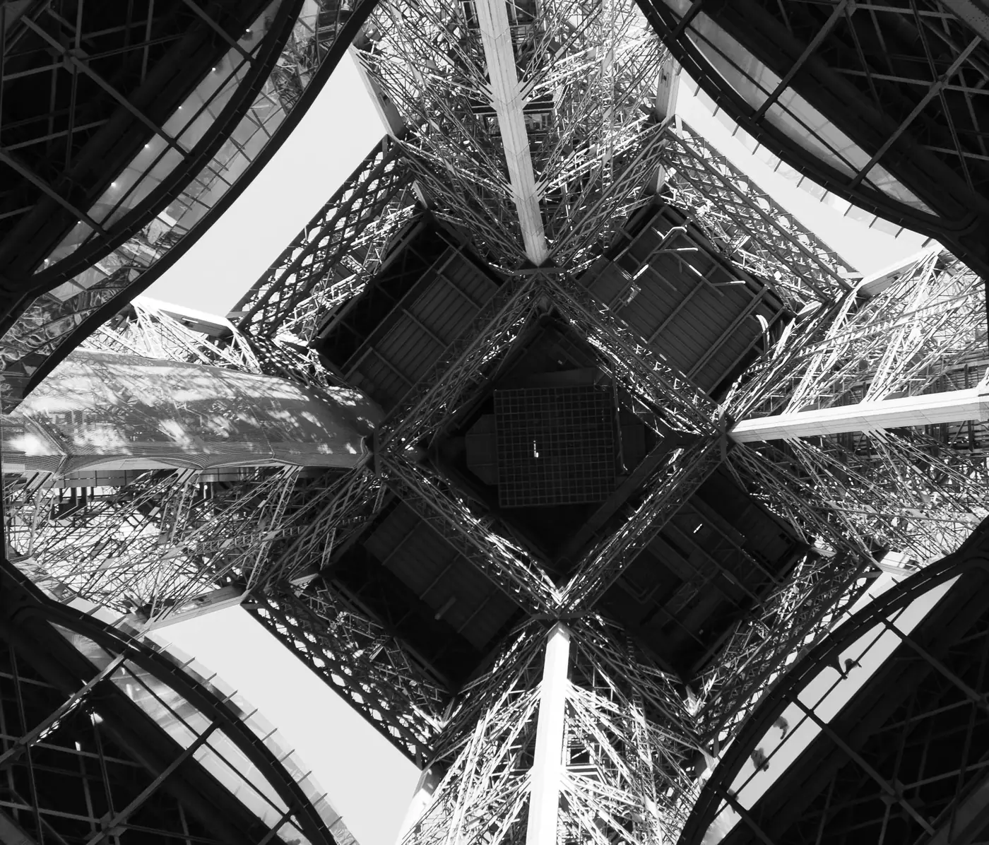A detailed black and white perspective of the Eiffel Tower's understructure in Paris, France.