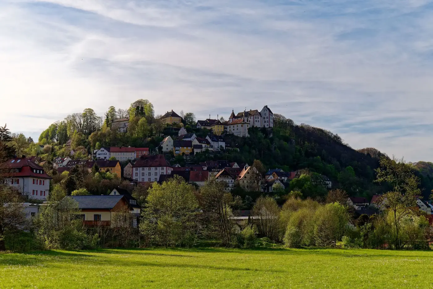 Picturesque hillside village of Egloffstein in Bavaria, Germany, surrounded by lush greenery.