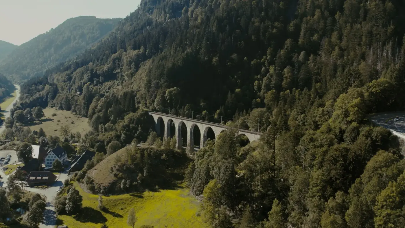 Drone view of the historic Hollental railway bridge in Breitnau, Germany, surrounded by lush forest.