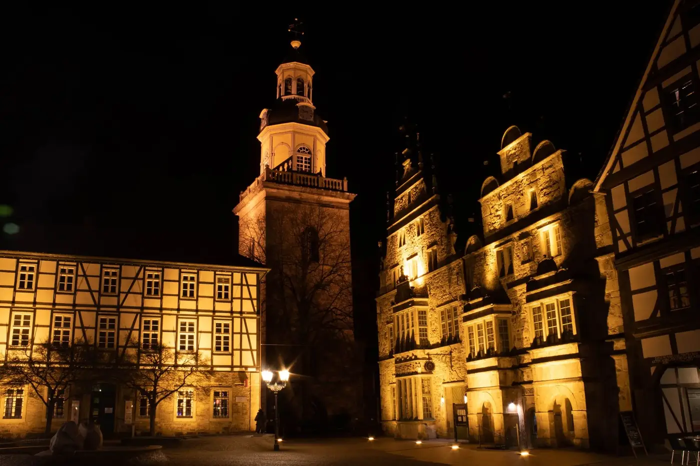 Illuminated historic buildings in Rinteln, Germany captured at night, showcasing traditional architecture.