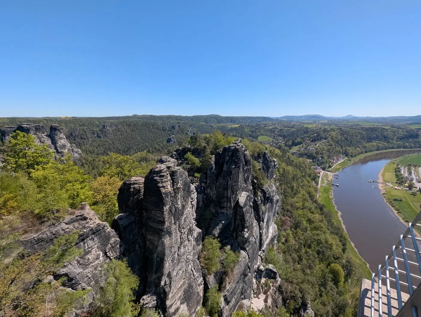 A breathtaking aerial view of the Elbe Sandstone Mountains and Elbe River under a clear blue sky.