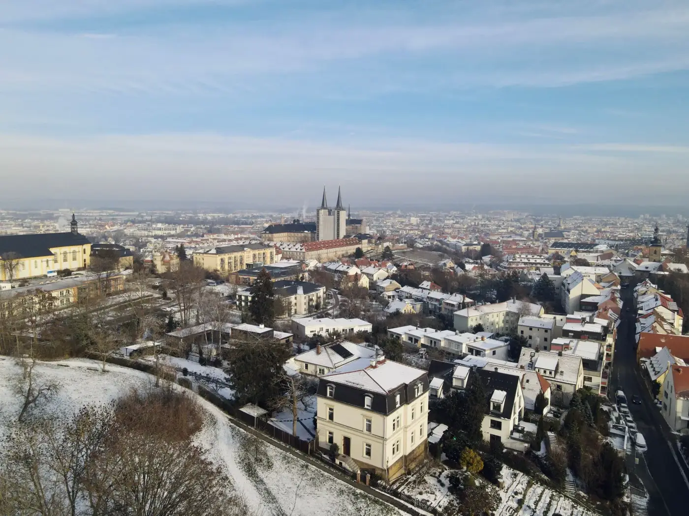 A stunning aerial view of a snow-covered cityscape with a prominent historical cathedral.