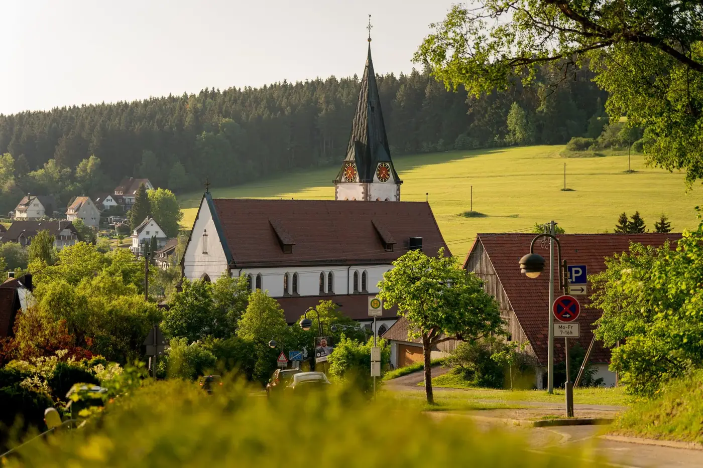 Charming rural landscape with church in Unterkirnach, Germany. Serene summer day with lush greenery.