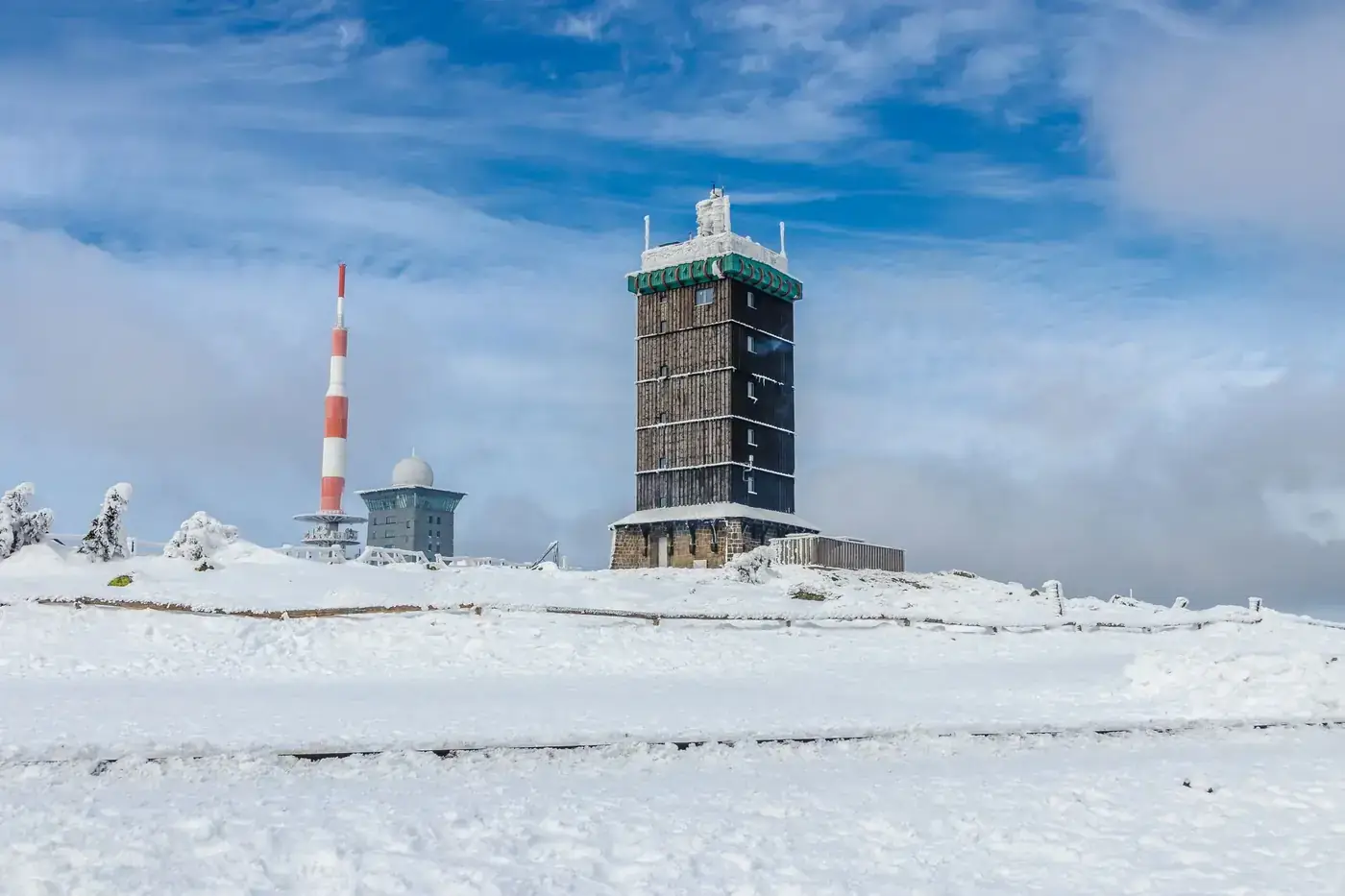 A scenic winter view of Brocken Tower surrounded by snow in Saxony-Anhalt, Germany.