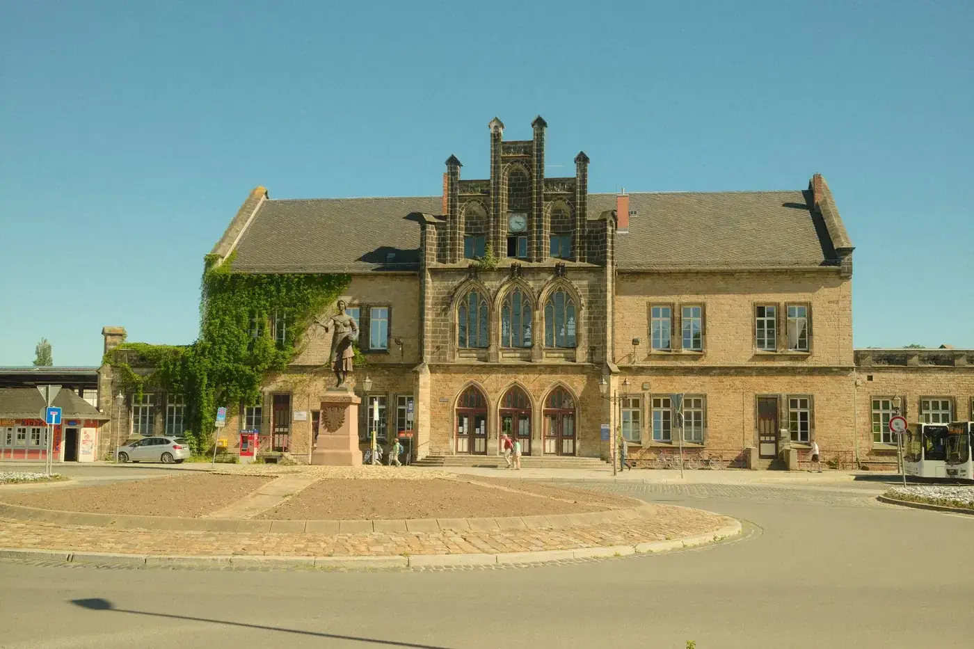 Vintage building with ivy and statue at a Harz, Germany train station on a sunny day.