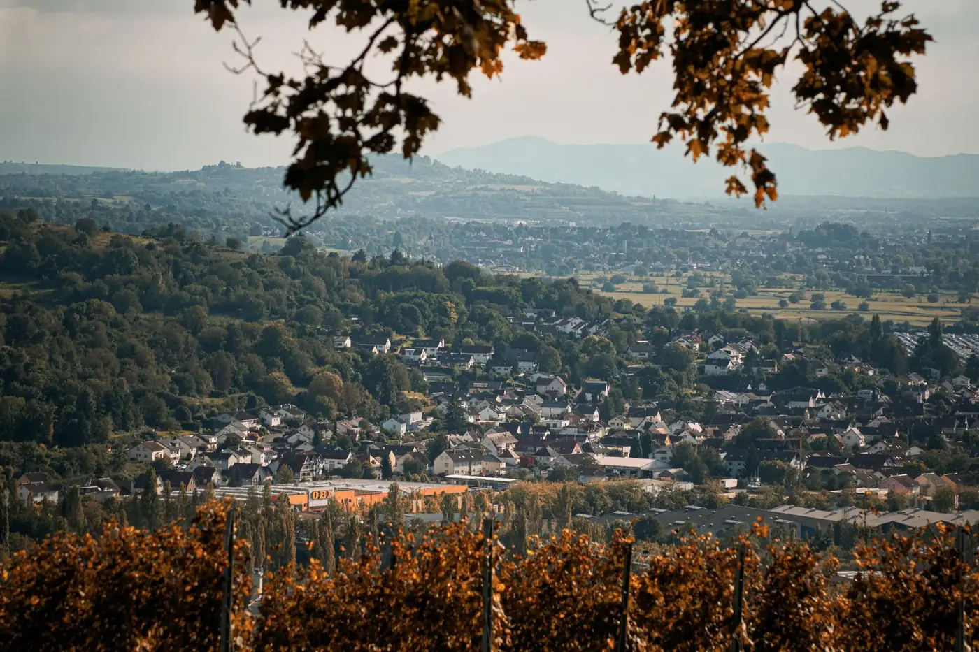 Picturesque autumn landscape overlooking a town in Baden-Württemberg surrounded by hills.