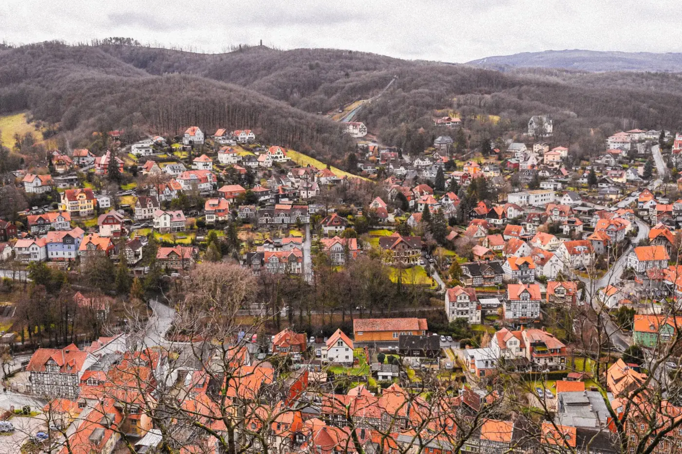 Aerial view of charming Wernigerode town with colorful rooftops and surrounded by scenic hills.