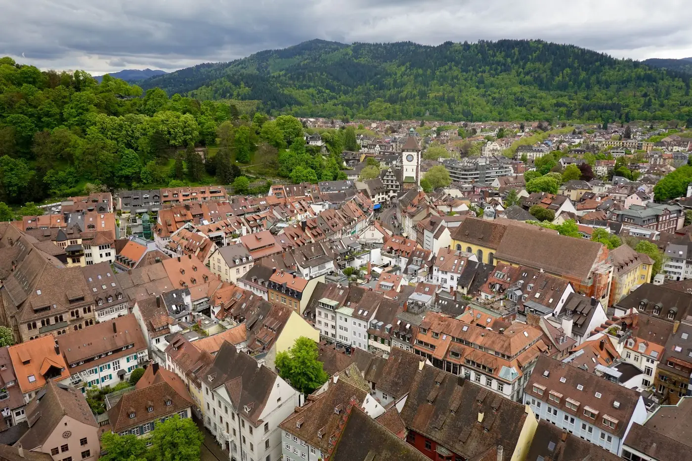 Charming aerial view of a Bavarian village with traditional architecture surrounded by lush green hills.