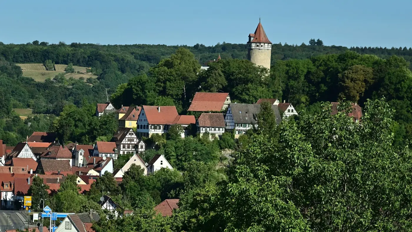 Charming townscape of Möckmühl with traditional houses and a historic tower amidst lush greenery.