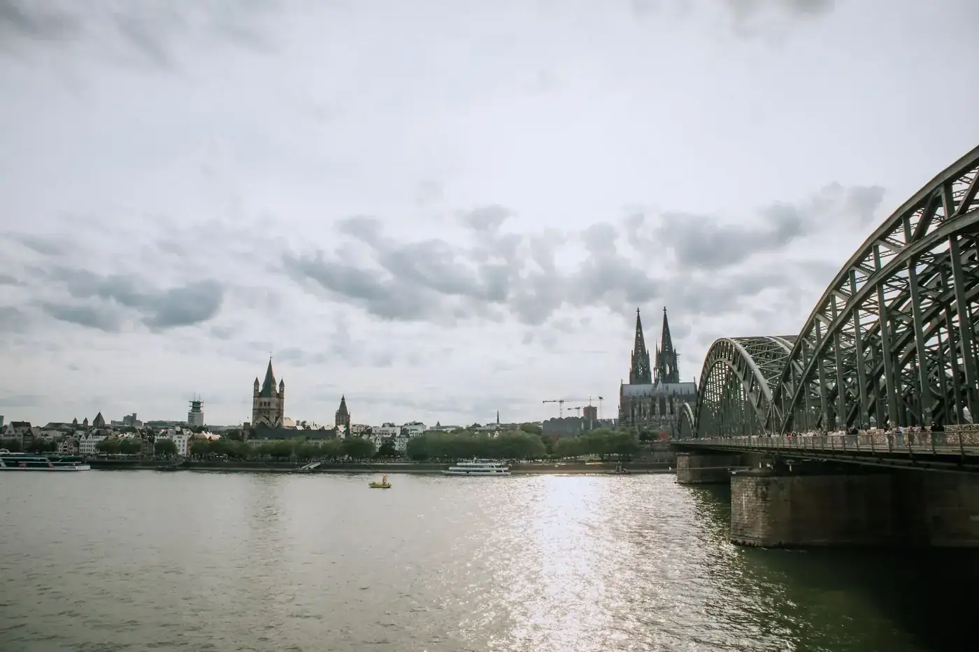 Captivating view of Cologne Cathedral with the Hohenzollern Bridge spanning over the Rhine River.
