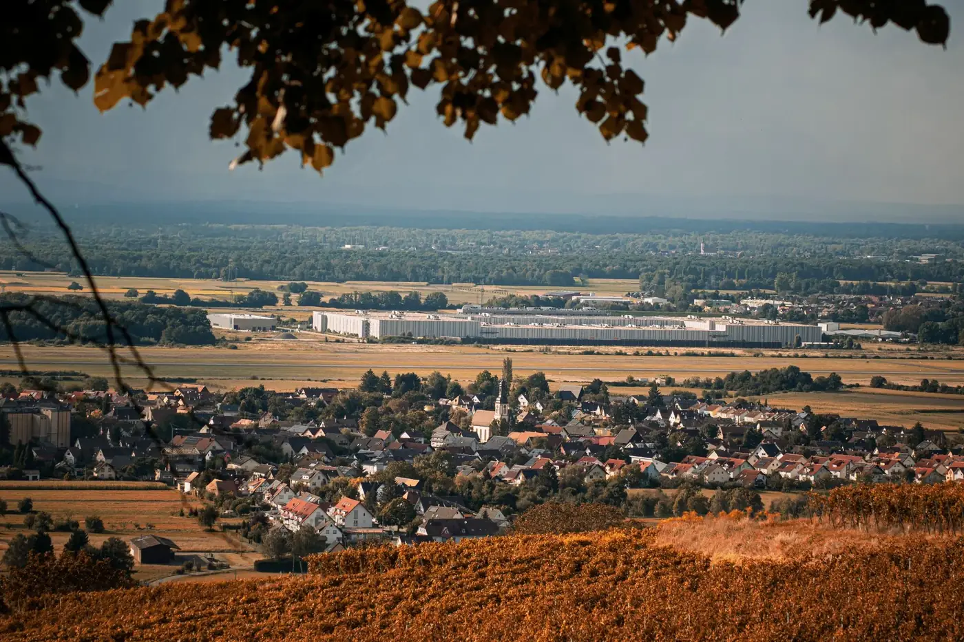 Picturesque view of a village surrounded by farmland in autumn with a clear distant landscape.