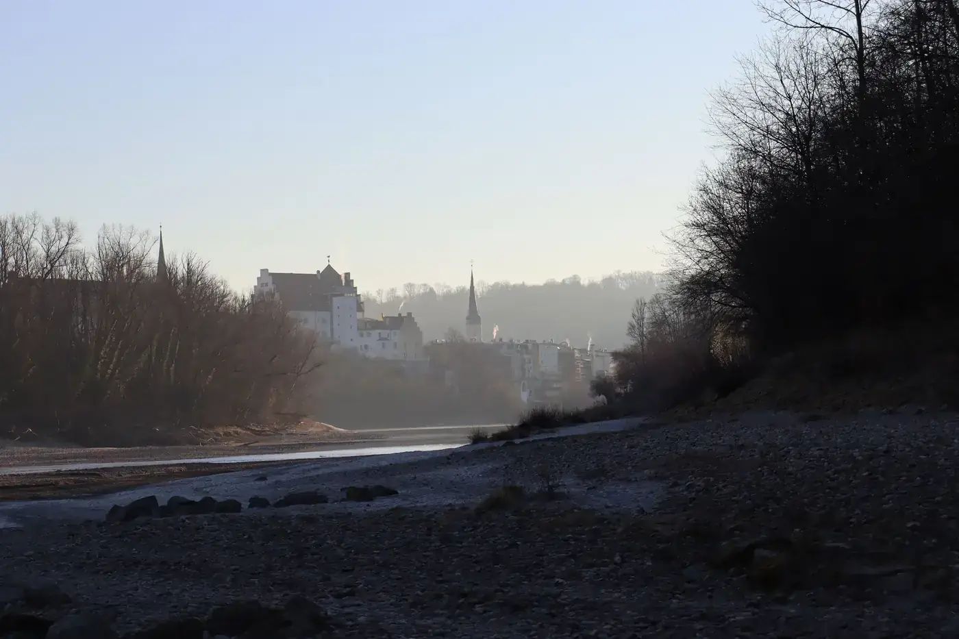 Wasserburg, Germany, townscape with misty river and leafless trees creating a serene winter scene.