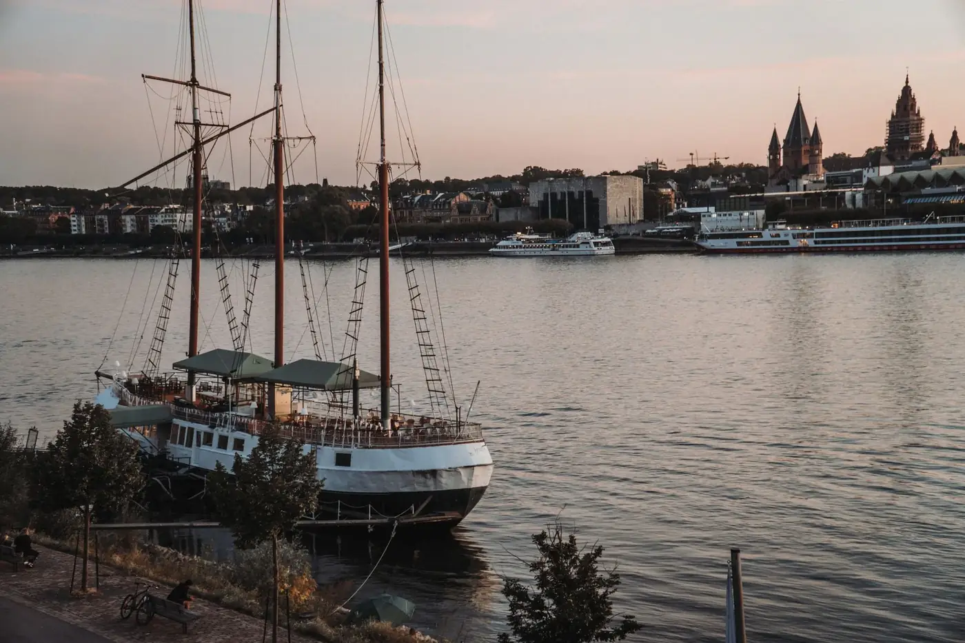 A tranquil evening view of a moored ship in the harbor with a city skyline backdrop.