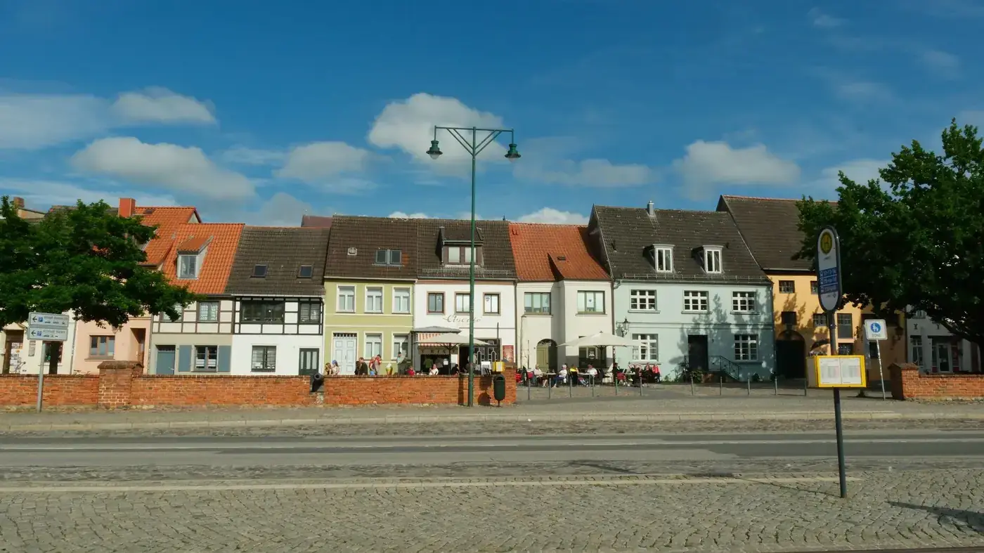 Charming colorful houses along a waterfront street in Wismar, Germany, on a sunny day.