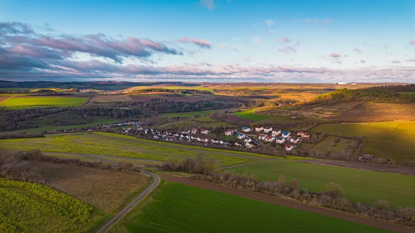 Stunning aerial view of German countryside with fields and villages under a vibrant sky.