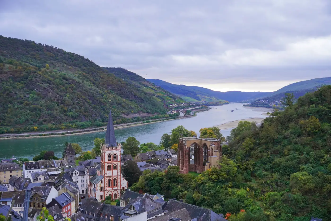 A breathtaking aerial view of Bacharach, Germany, featuring the Rhine River and lush hillside landscapes.