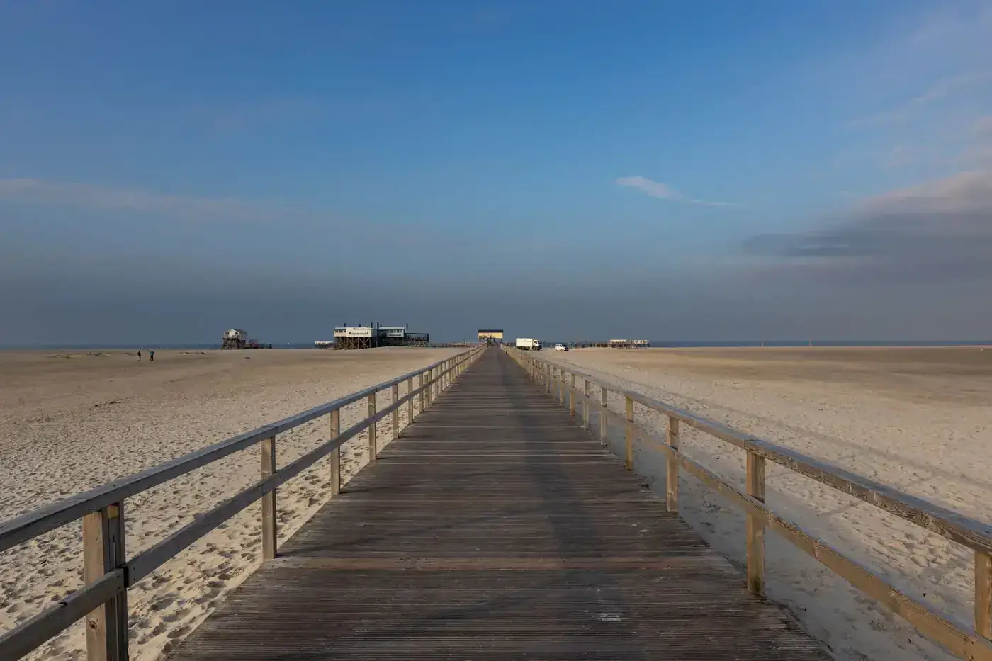 Scenic view of a wooden pathway leading to the beach in Sankt Peter-Ording, Germany.