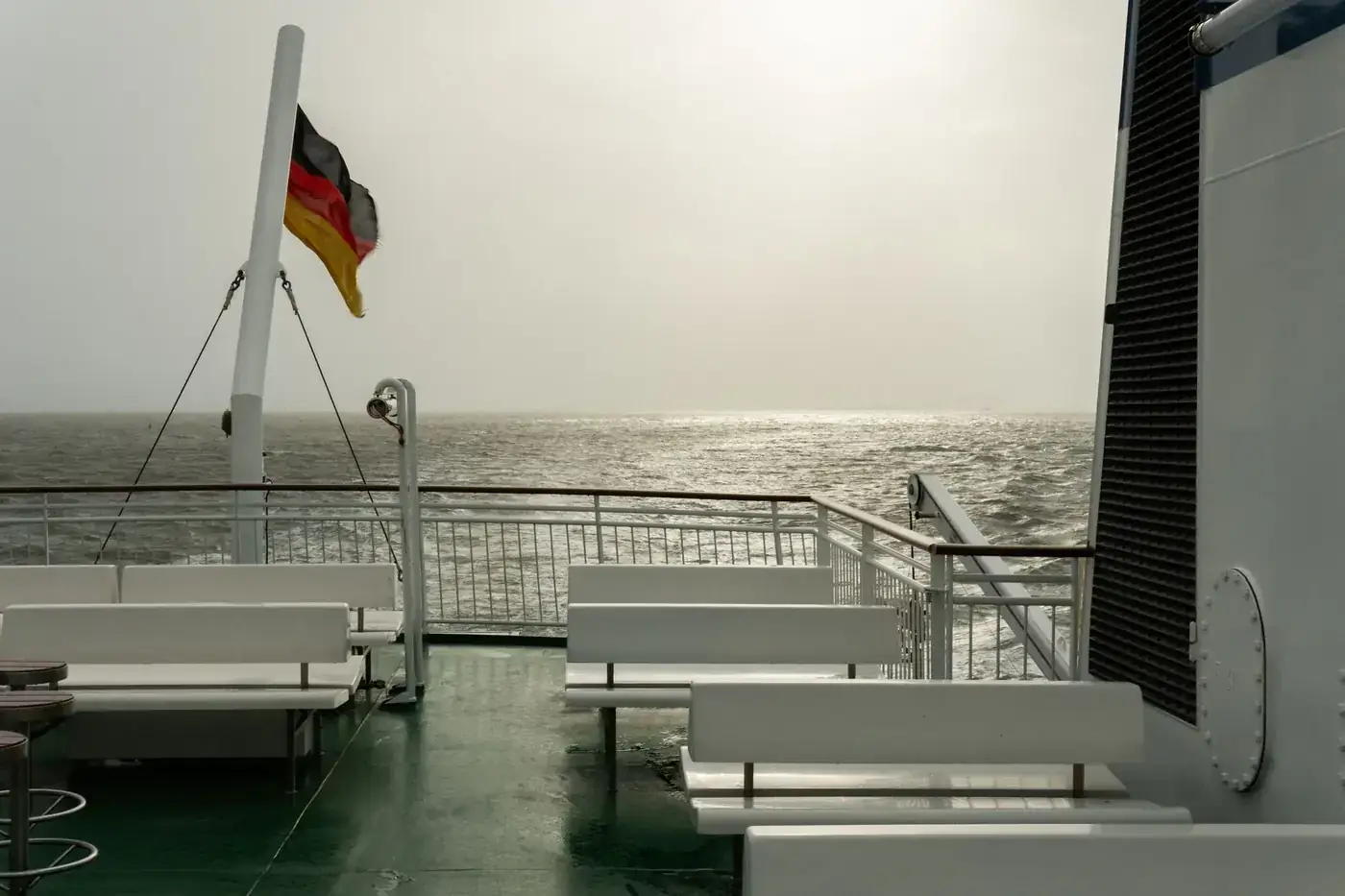 Empty ferry deck with German flag and sea view in Borkum, Germany.