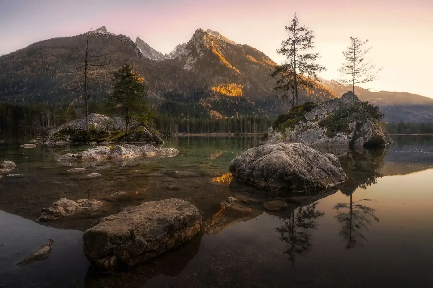 Calm Hintersee Lake reflecting mountains at sunset in Ramsau bei Berchtesgaden, Germany.