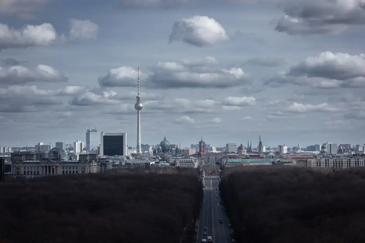 A captivating aerial view of Berlin showcasing the iconic TV tower under a dramatic cloudy sky.