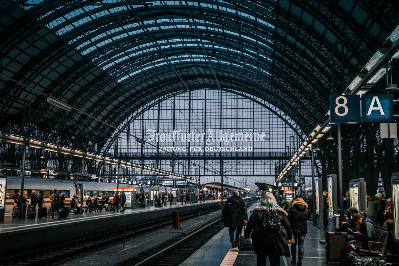 Interior view of Frankfurt Hauptbahnhof with trains and commuters.