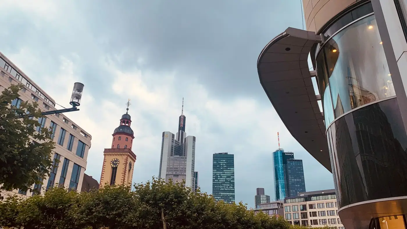 A captivating view of Frankfurt's skyline featuring iconic skyscrapers and a historic clock tower.