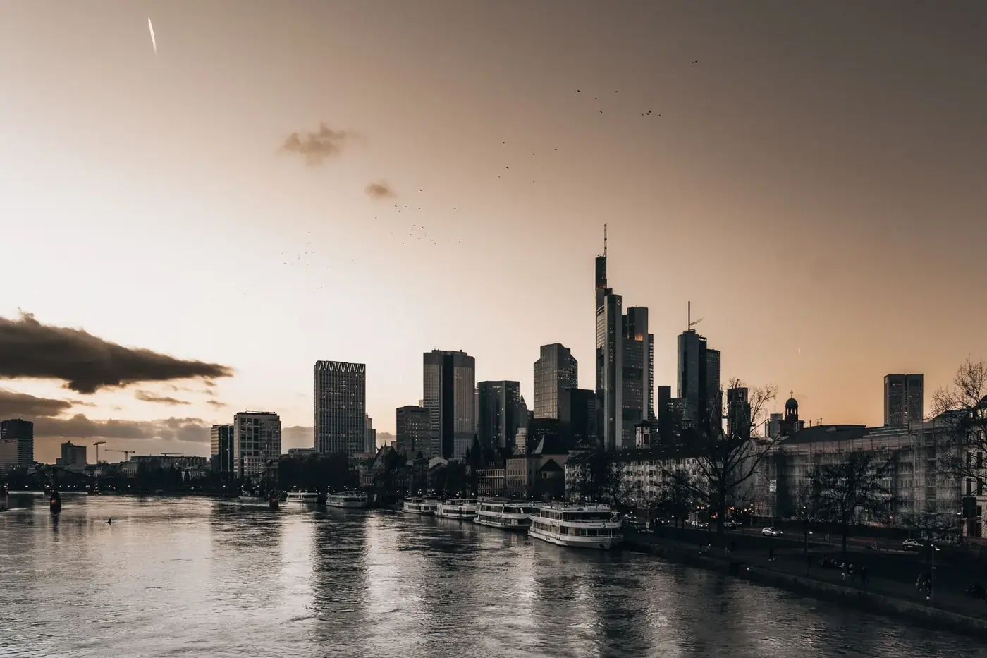 Stunning view of Frankfurt's skyline during twilight, reflecting on the river.