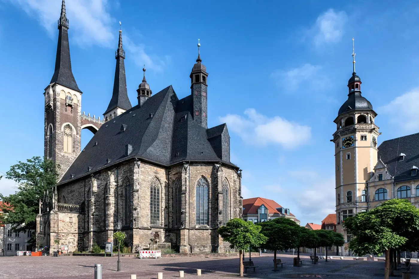 Capture of a historic church and clock tower in the sunny town square of Köthen, Germany.