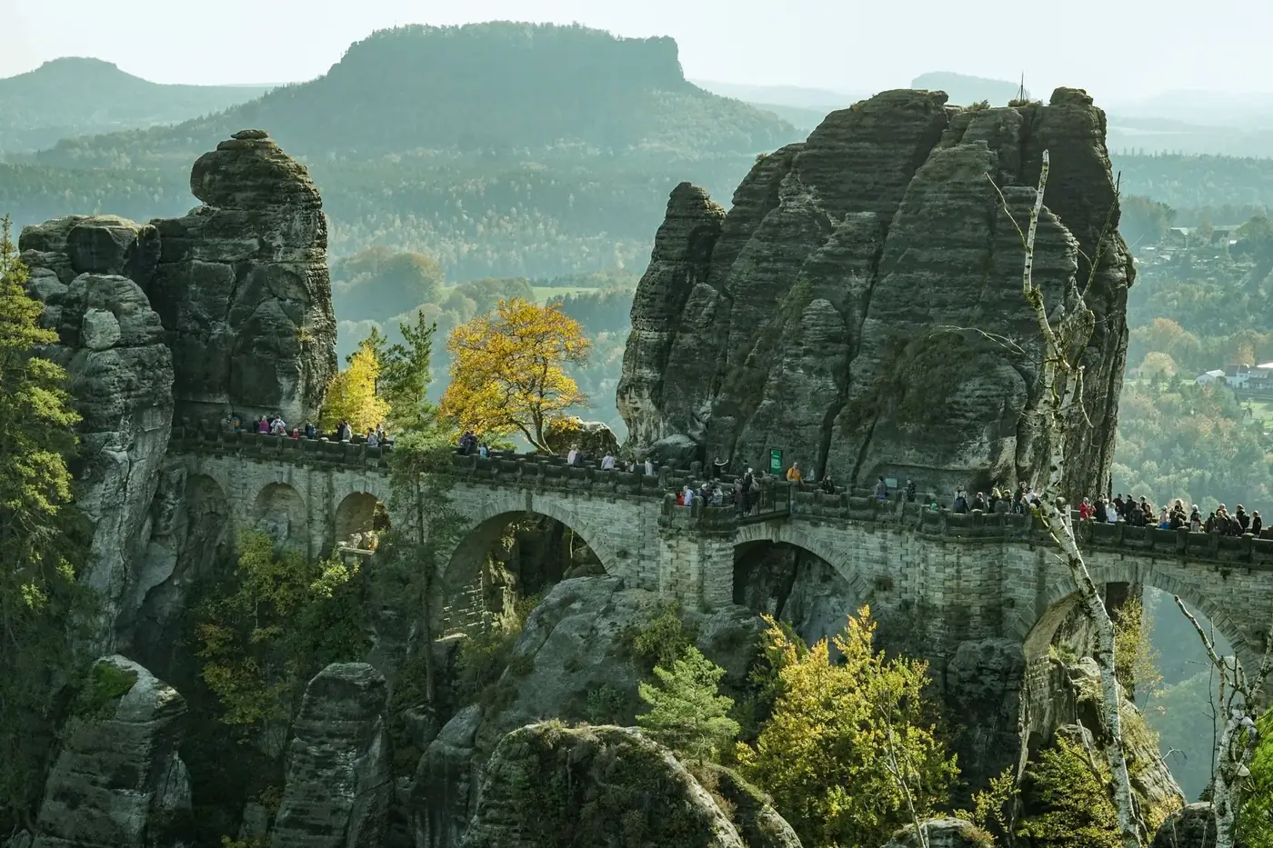 Scenic view of Bastei Bridge surrounded by autumn foliage in Saxony, Germany.