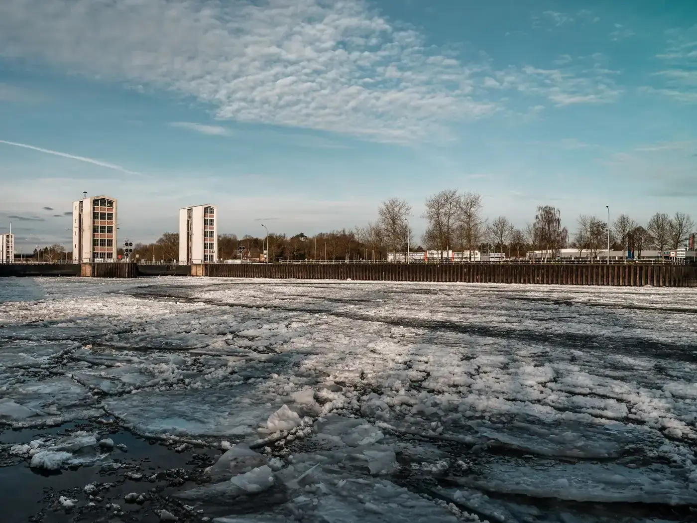 Explore the frozen landscape of the Geesthacht River with drifting ice floes under a clear winter sky.