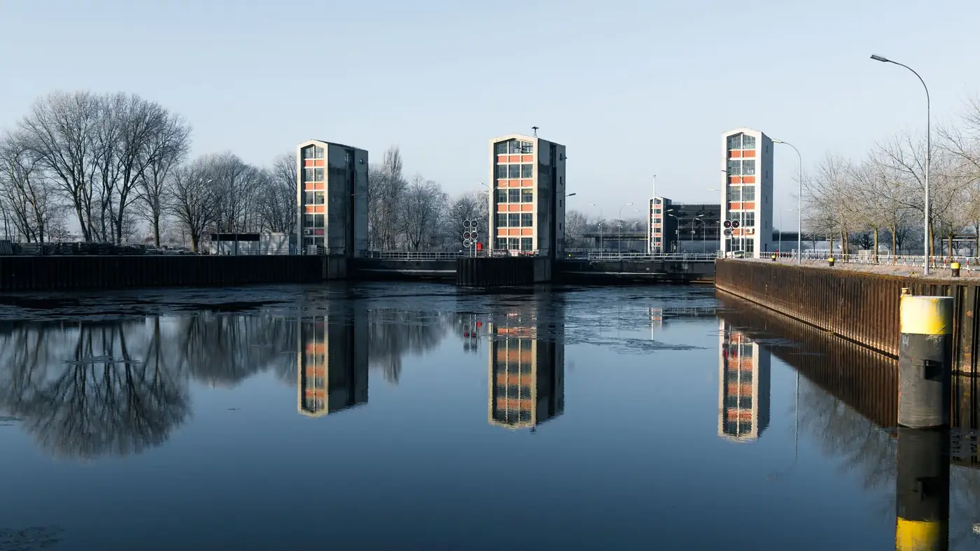 Idyllic view of the Geesthacht canal featuring a reflective floodgate on a serene day.