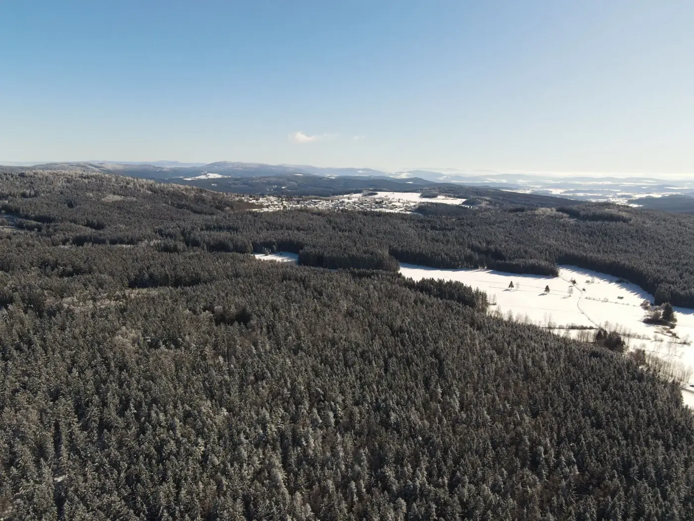 A breathtaking aerial view of snow-covered forests and hills in Schönsee, Germany.