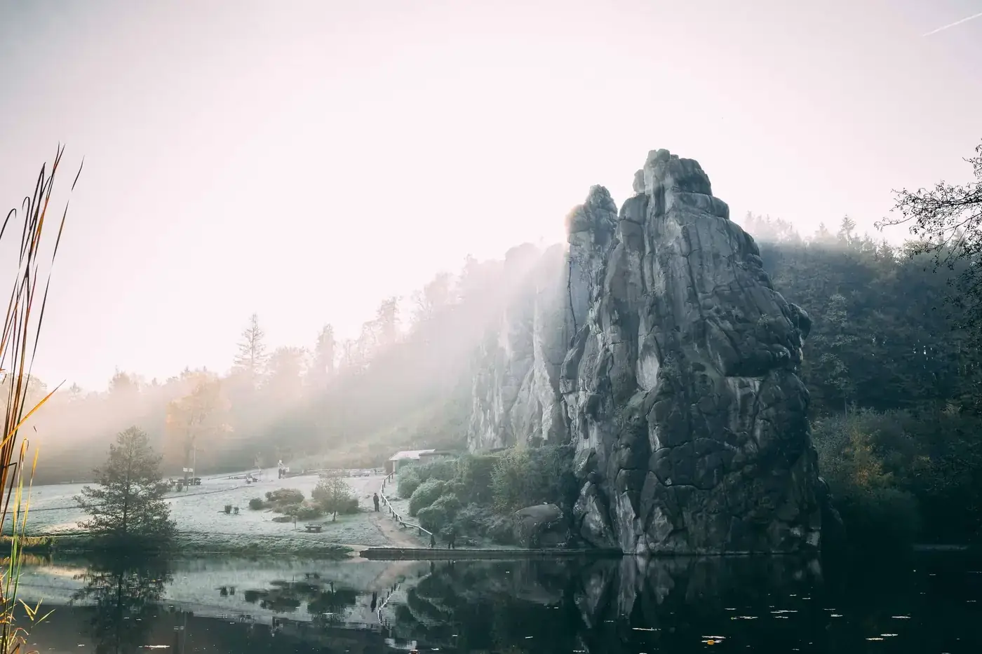 Scenic view of Externsteine rocks in Germany with misty reflections at sunrise.