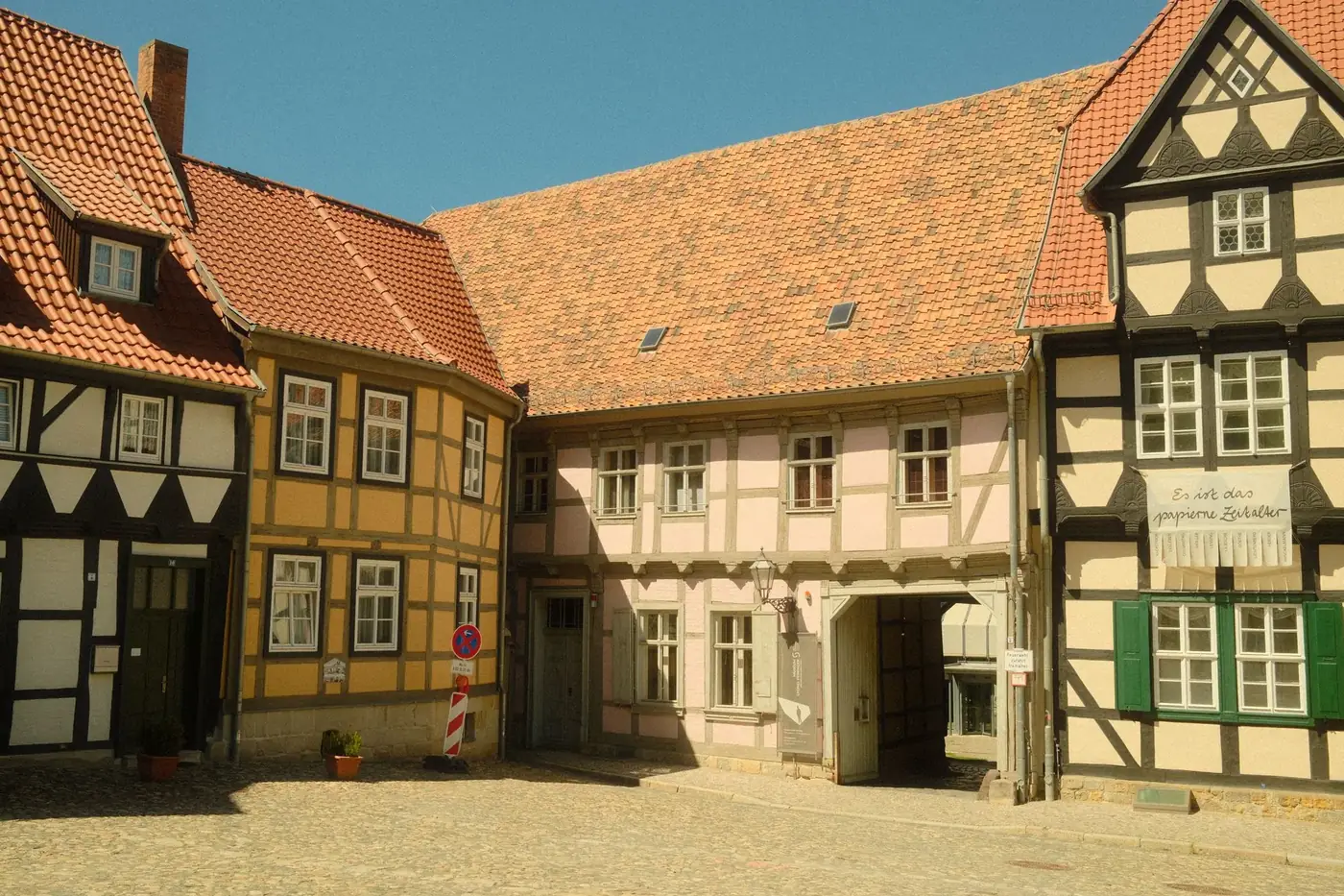Charming half-timbered houses in Quedlinburg, Germany, showcasing medieval architecture under a clear blue sky.