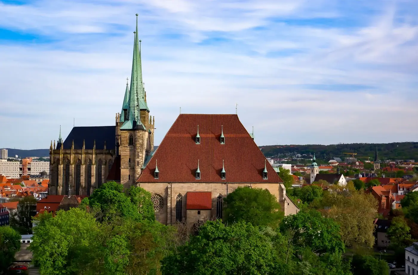 Stunning aerial view of a Gothic cathedral in a vibrant cityscape, bathed in summer light.