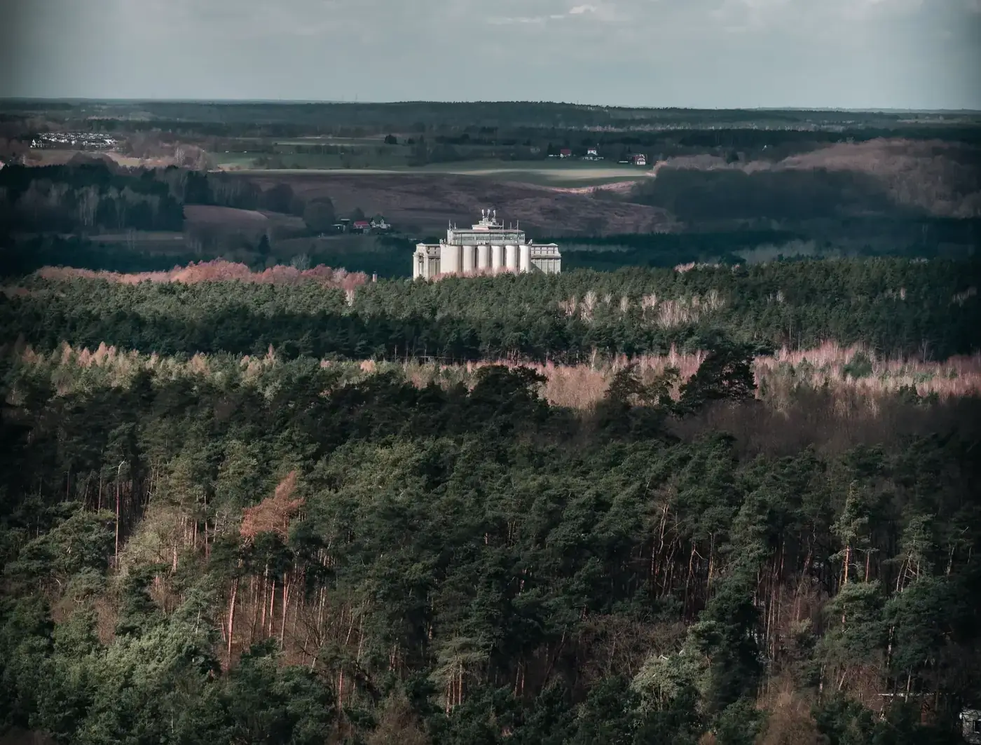 Aerial view of a forest with a building in Czerwonak, Poland, showcasing natural and rural landscape.