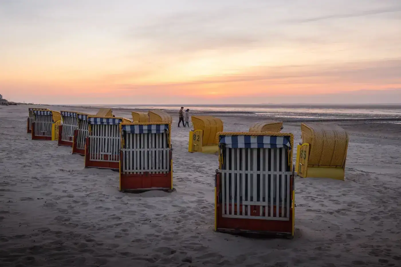 Beach chairs on Cuxhaven beach at sunset, offering a serene and picturesque view.