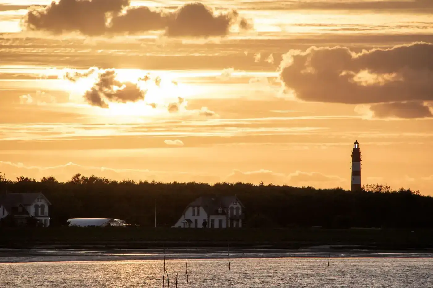Captivating sunset view of Wittdün lighthouse and coast on Amrum Island.