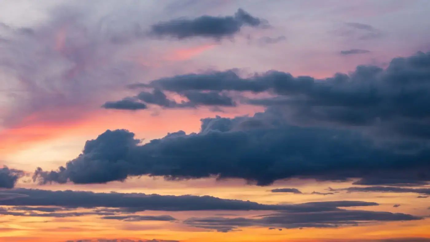 Dramatic clouds cast against a vibrant sunset sky in Hachenburg, Germany.