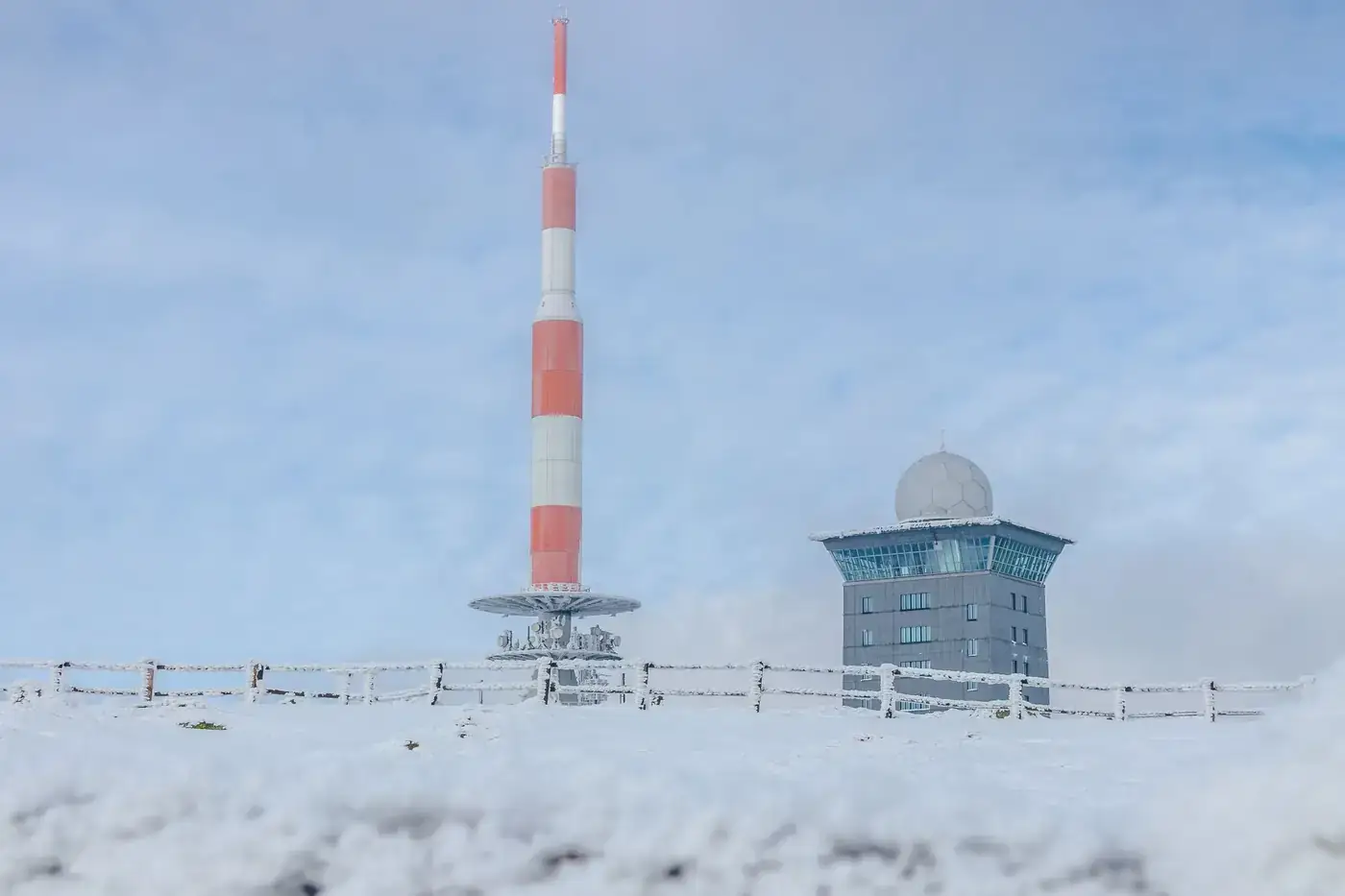 Snow-covered landscape featuring Mount Brocken's radar tower and radio mast in Saxony-Anhalt.