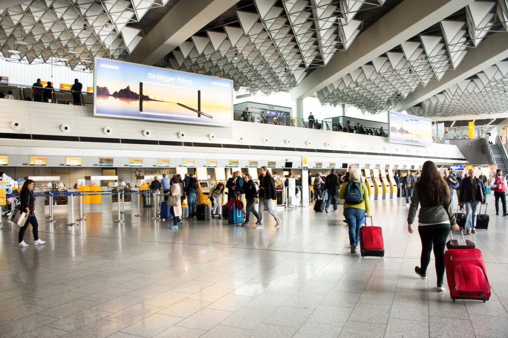 Duitse en buitenlandse reizigers wachten vlucht met passagiers die aankomen en vertrekken op de internationale luchthaven van Frankfurt
